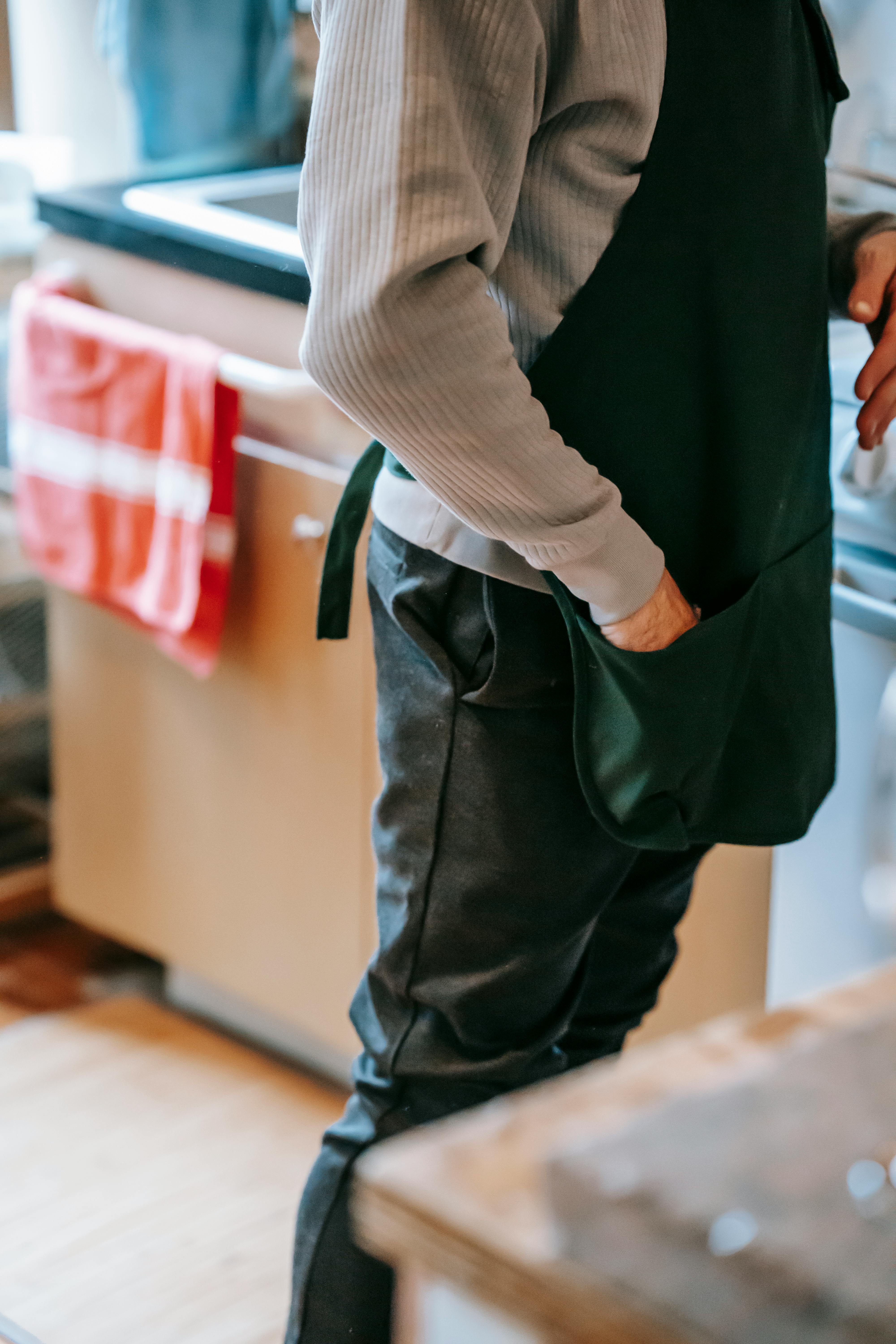 woman in apron standing in kitchen in daytime