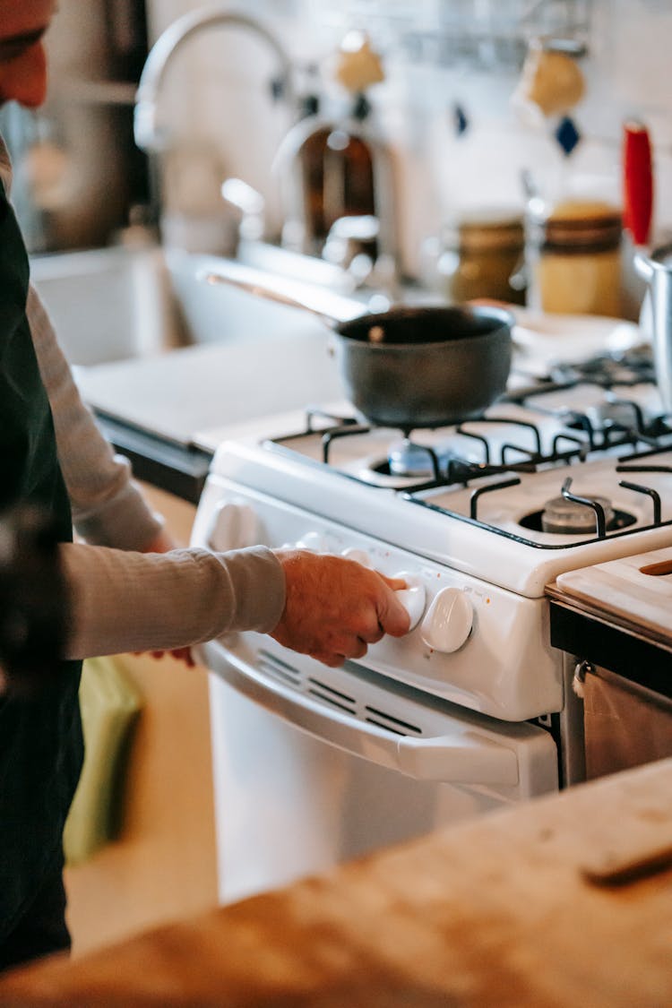 Unrecognizable Man Cooking On Stove With Pan In Kitchen