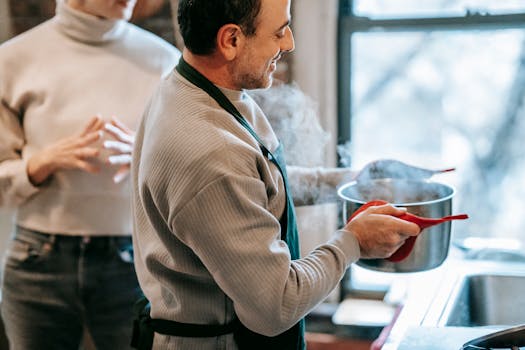 Middle-aged couple preparing a homemade meal together in a cozy kitchen, enjoying the process and aroma.