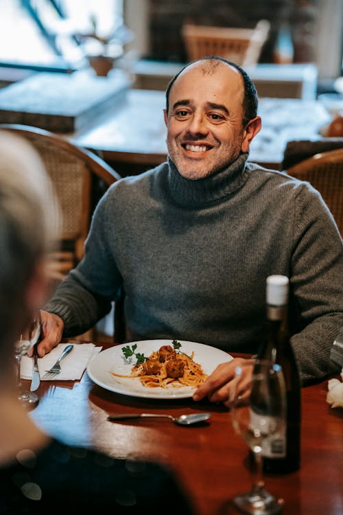 Uomo In Maglione Grigio Che Si Siede Sulla Sedia