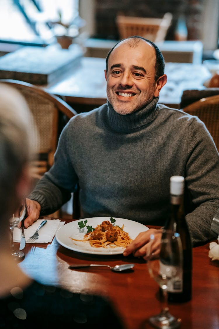 Positive Couple Having Dinner In Restaurant With Pasta And Wine