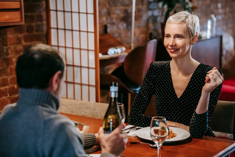 Couple Having Dinner With Pasta And Wine In Room