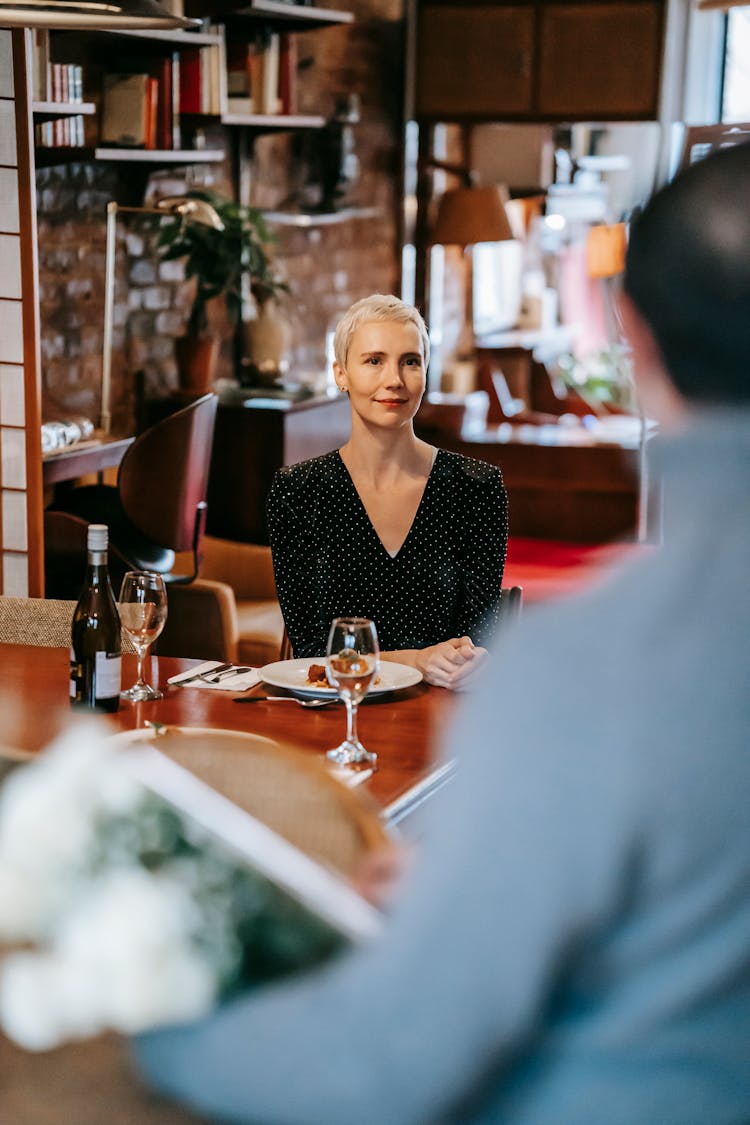 Male With Flowers Bouquet While Couple Having Dinner In Restaurant