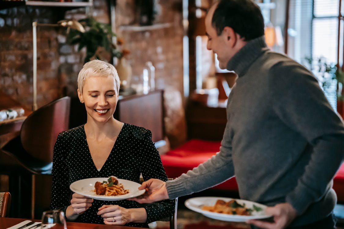Free Smiling couple having date with food in restaurant Stock Photo