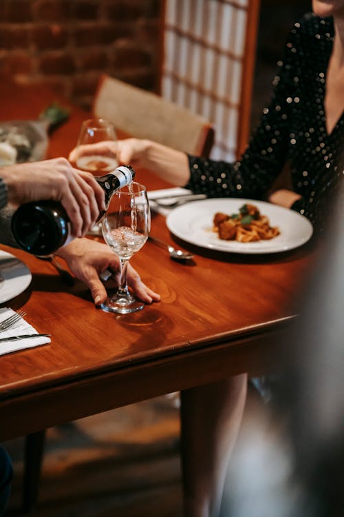 Persona Che Versa Vino In Un Bicchiere Da Vino