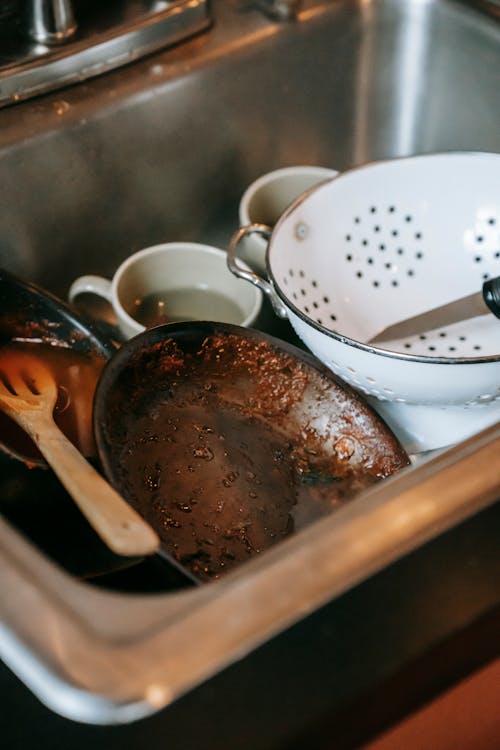 Free High angle heap of dirty dishes placed in sink after cooking in kitchen Stock Photo