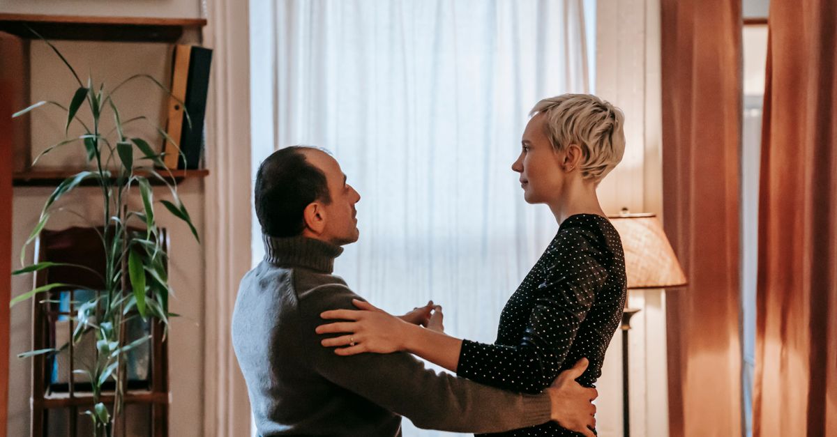 two people slow dancing in a kitchen at golden hour, candid and intimate