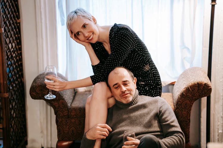 Cheerful Couple Relaxing On Couch With Wineglasses