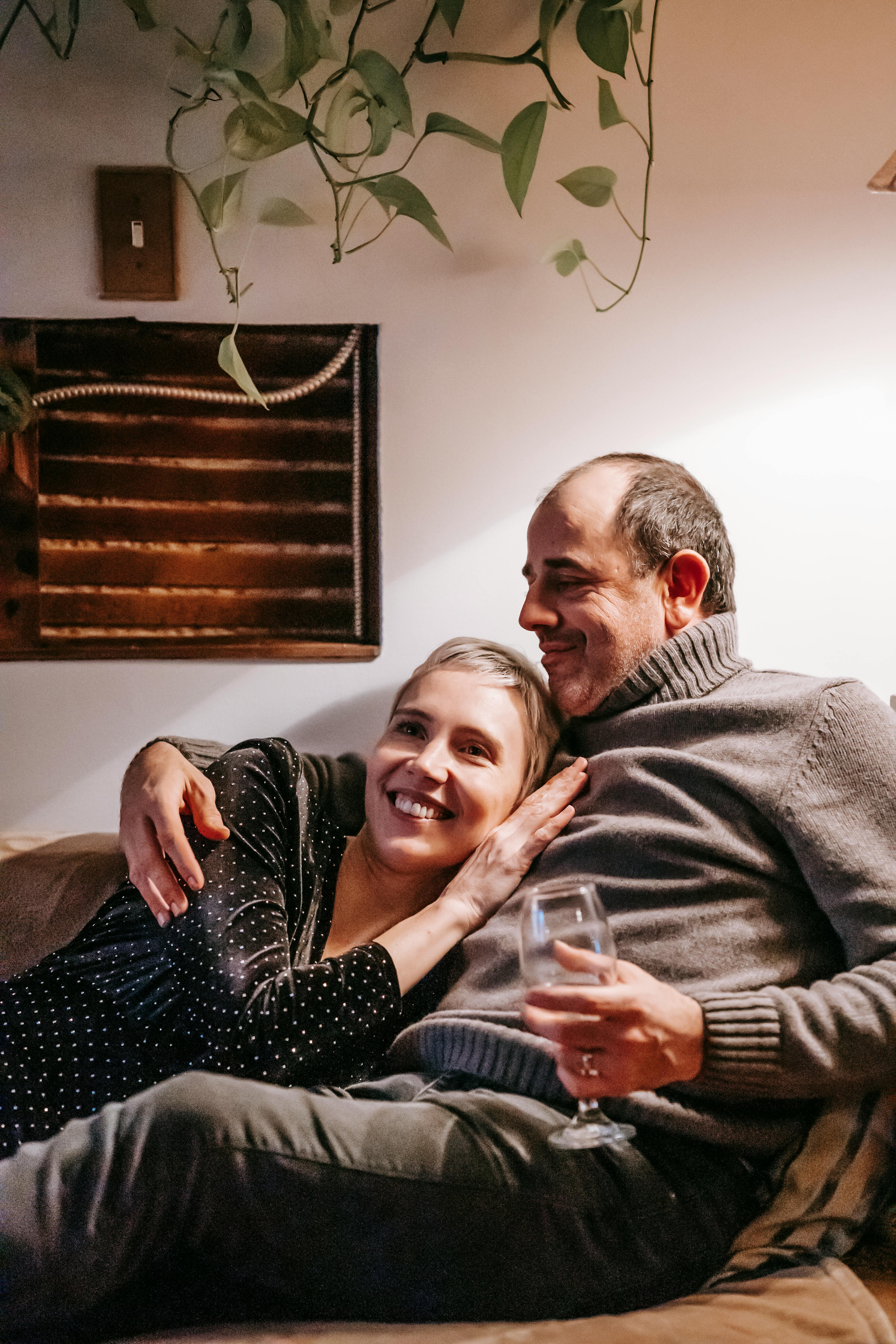 smiling couple relaxing on sofa at home