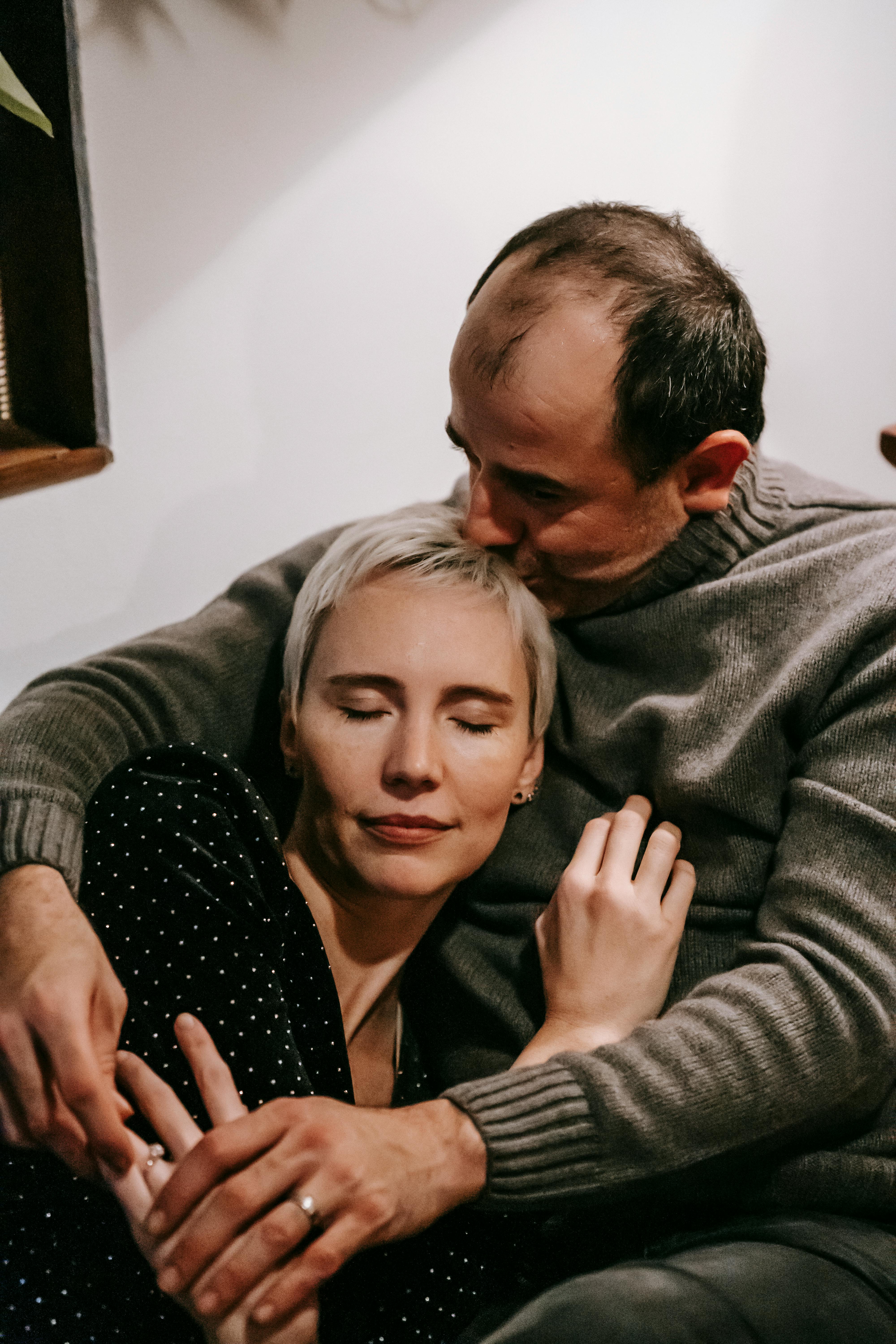 loving couple embracing gently sitting at home