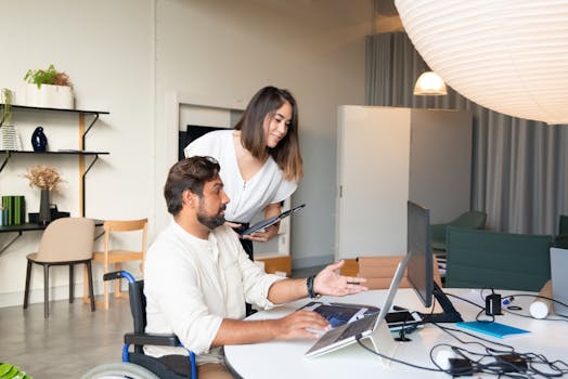 Diverse coworkers collaborating on a project in a modern office space with accessible facilities.