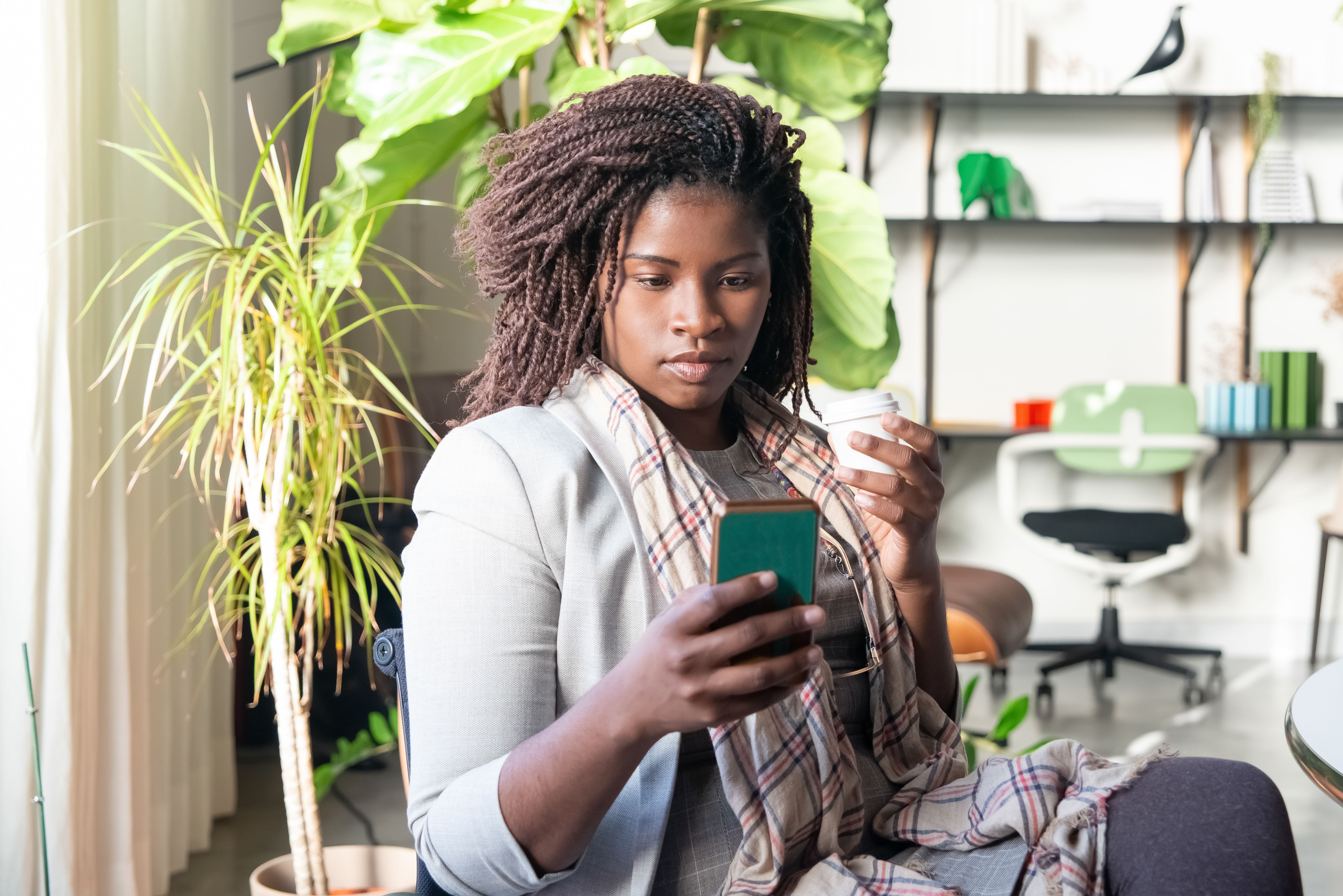 Femme aux cheveux tressés utilisant son téléphone portable · Photo gratuite