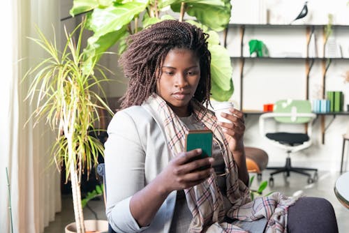 A Woman with Braided Hair Using Her Cellphone