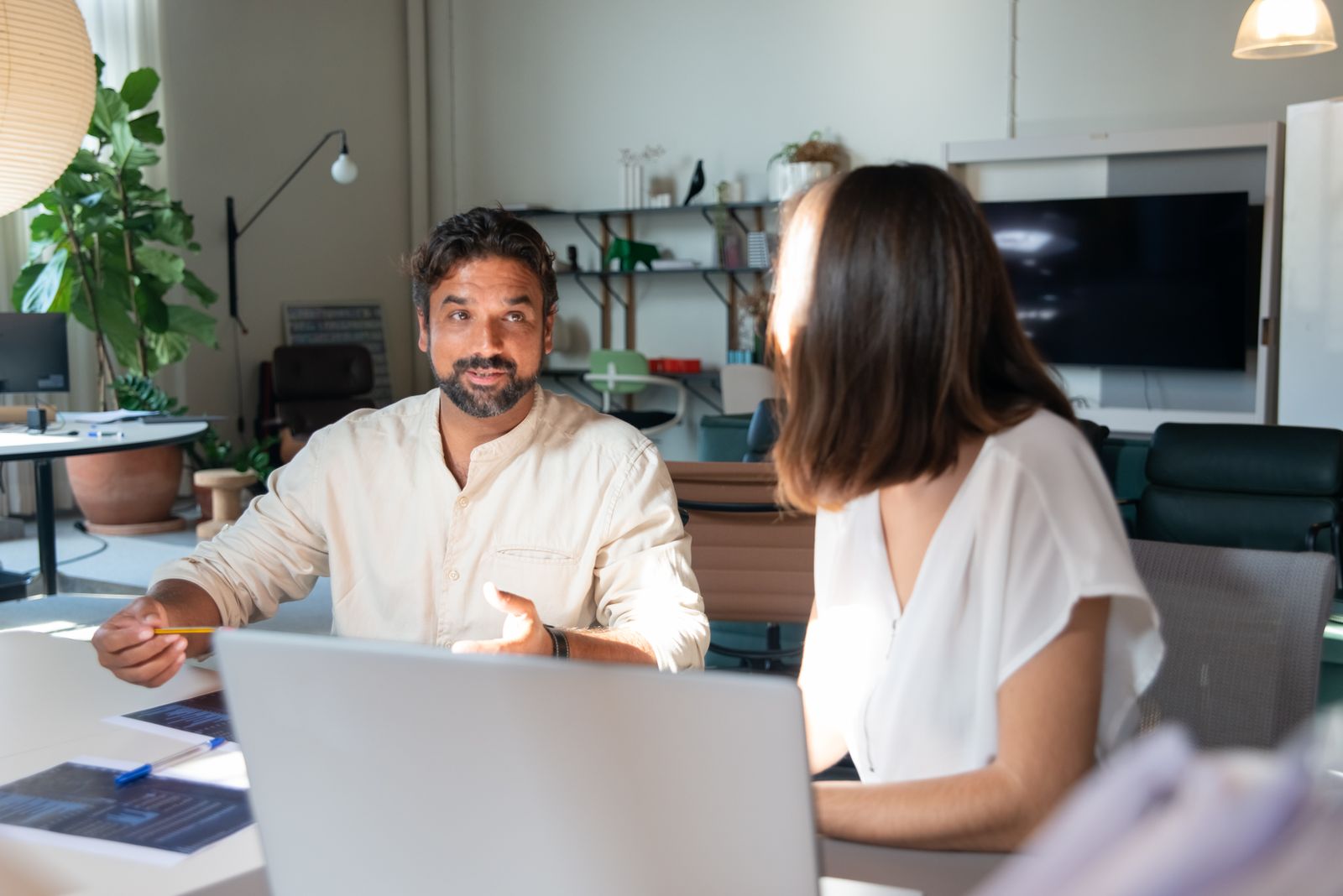 Two Gabbro colleagues talking across a desk in a daylit studio workspace. Photo by Kampus Production on Pexels.