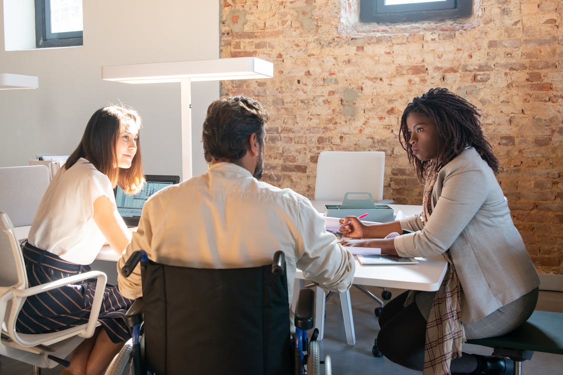 Photo of a Man and Women Talking at a Office