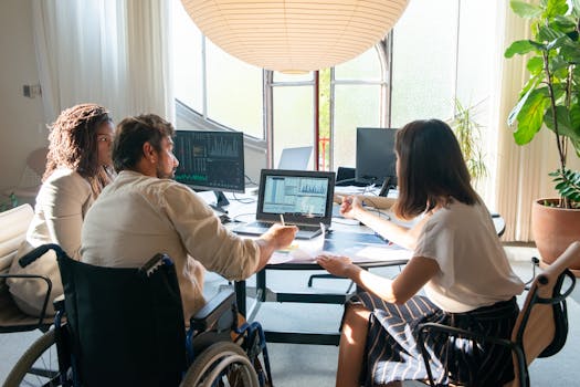 Team of diverse coworkers discussing charts and graphs at a bright, modern office table.