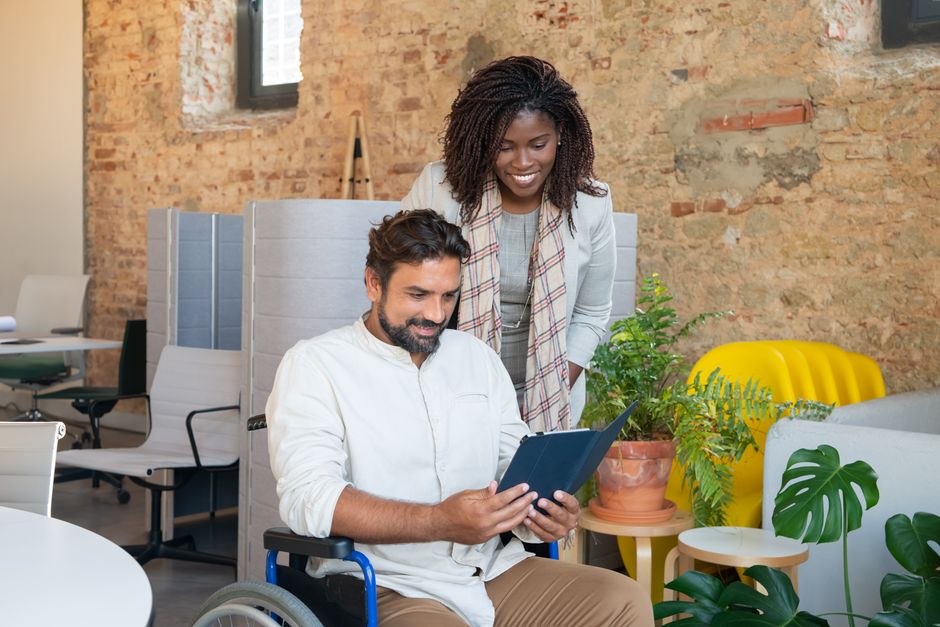 Profesionales diversos colaborando en una oficina moderna, enfocándose en tecnología y trabajo en equipo.