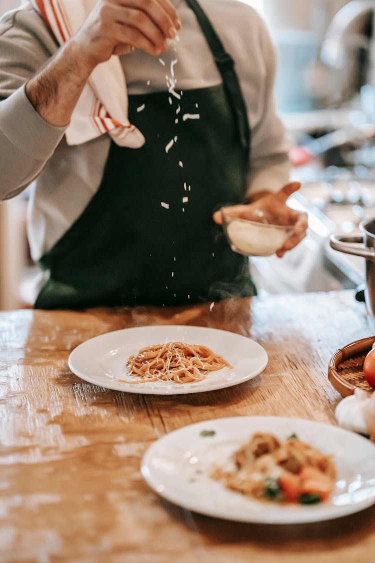 Unrecognizable Man Cooking Pasta On Counter In Kitchen