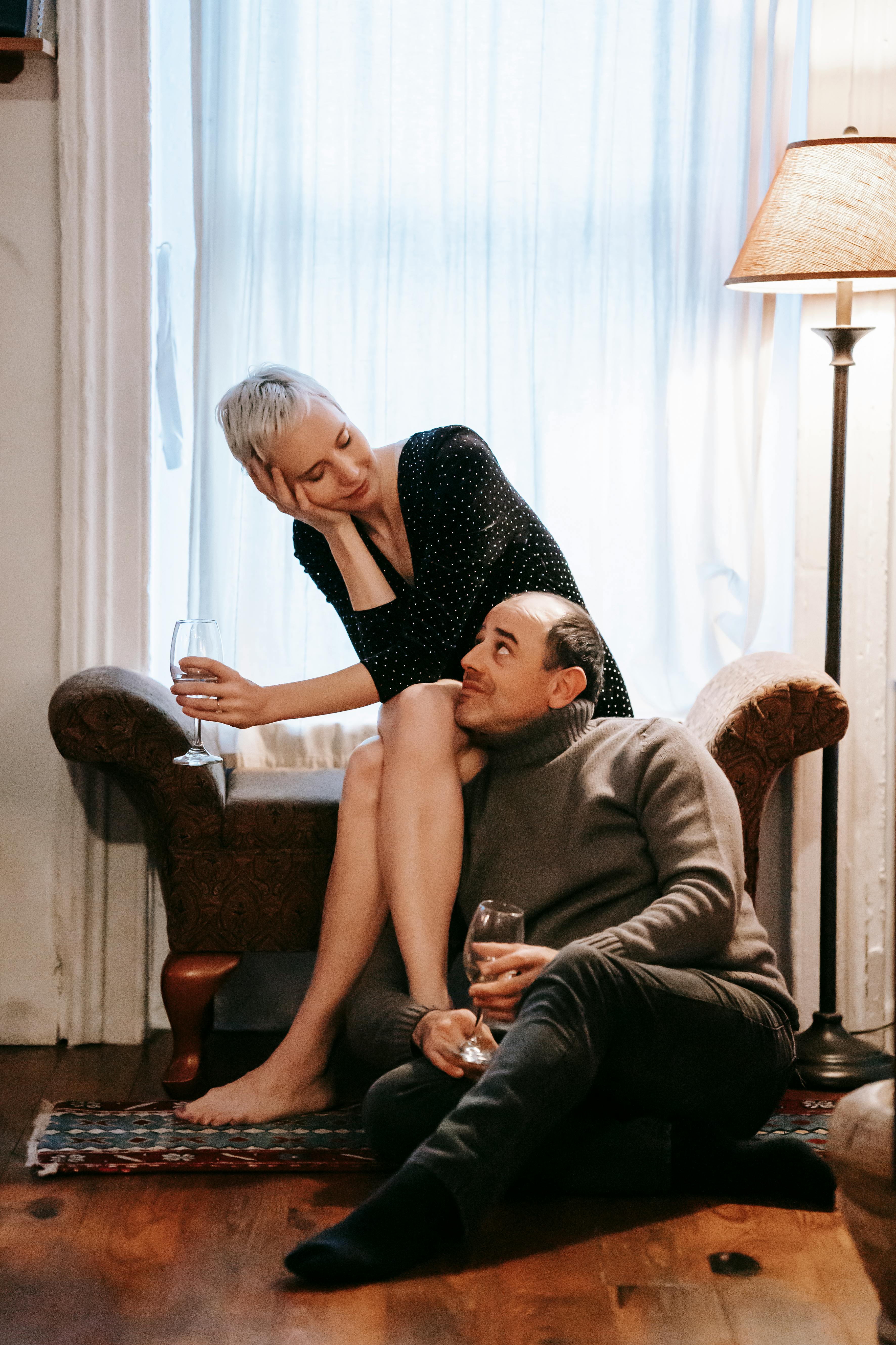 relaxed couple with glasses of wine sitting close