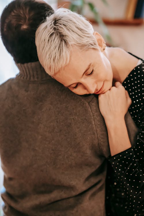 Loving delicate woman with closed eyes embracing husband