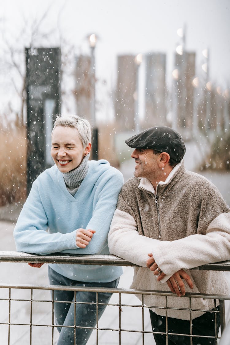 Cheerful Couple Enjoying Snowfall In Park