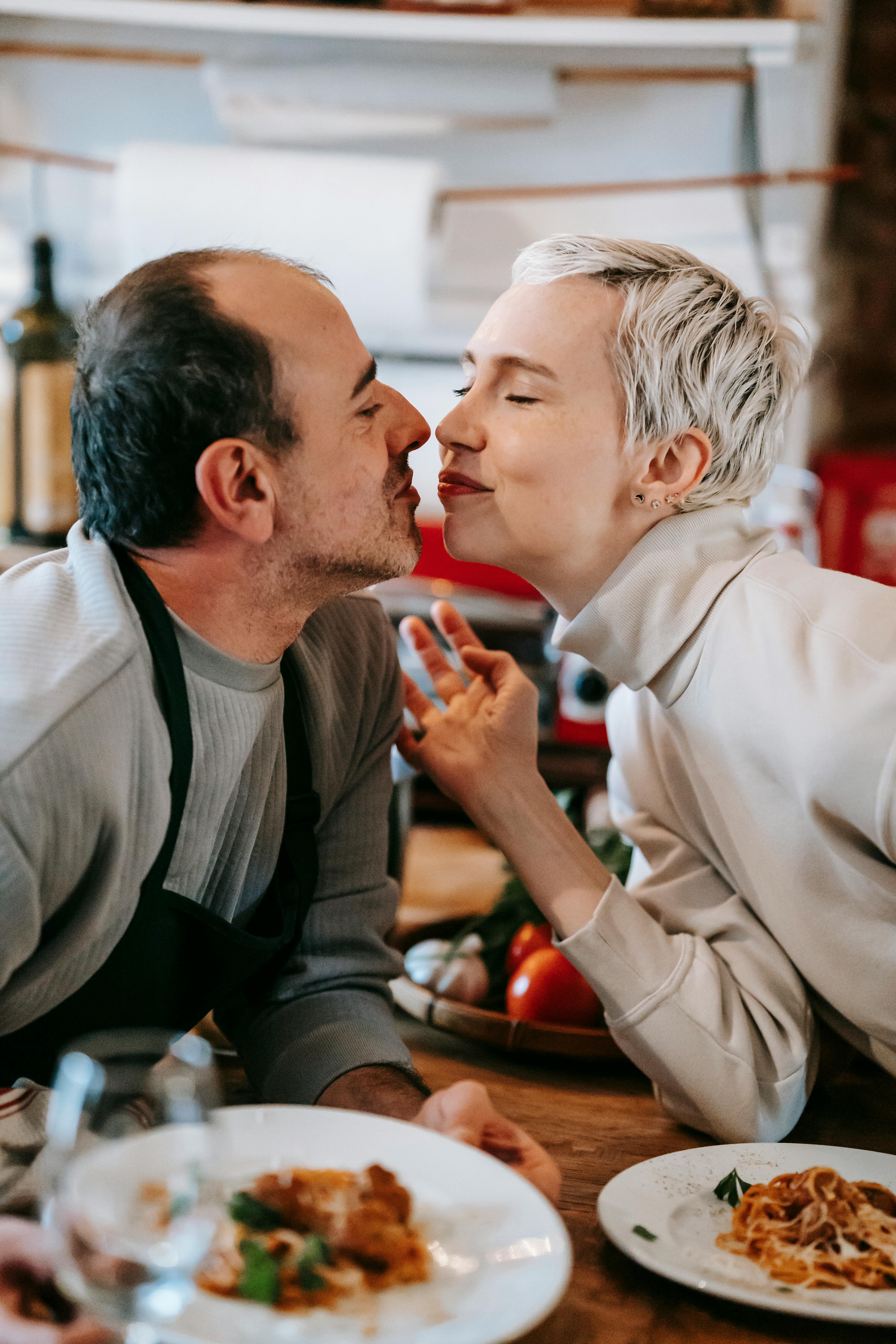 loving couple kissing each other while having dinner