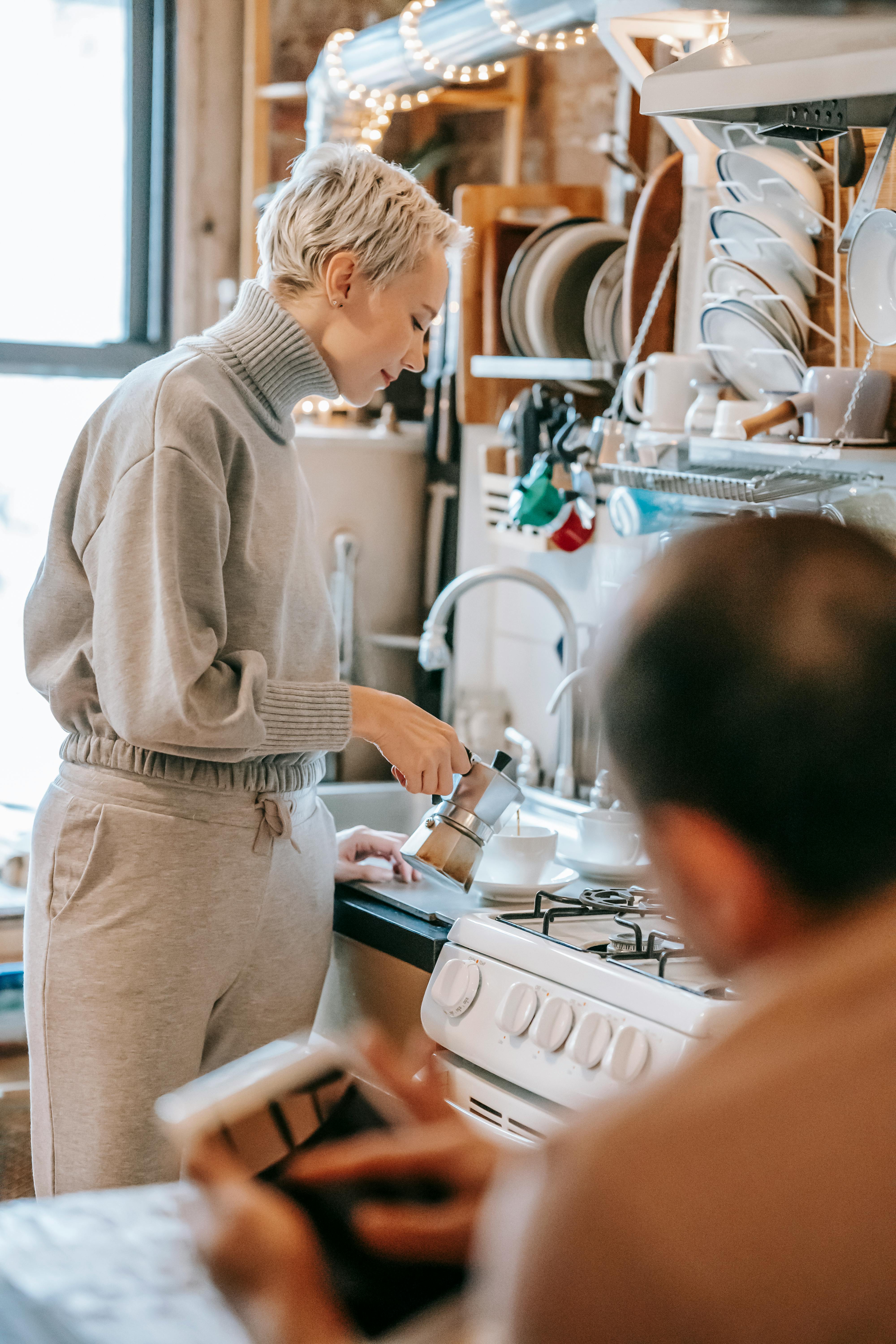 smiling woman pouring drink from coffee maker