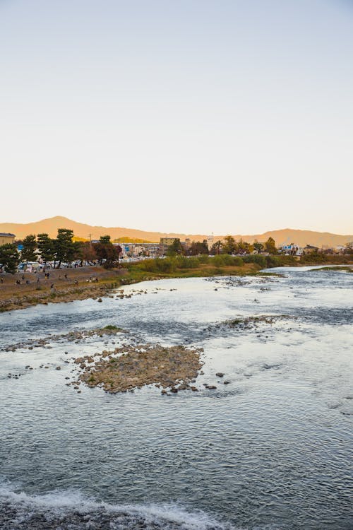 Picturesque scenery of rippling sea surrounded by hill against cloudless blue sky in countryside