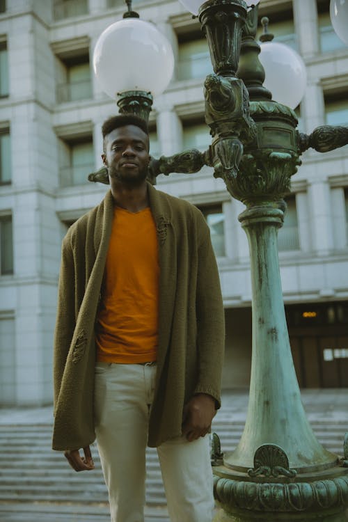 Trendy black man standing near streetlight