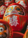 From below stack of traditional red painted Japanese daruma dolls symbolizing good luck placed on local market on sunny street