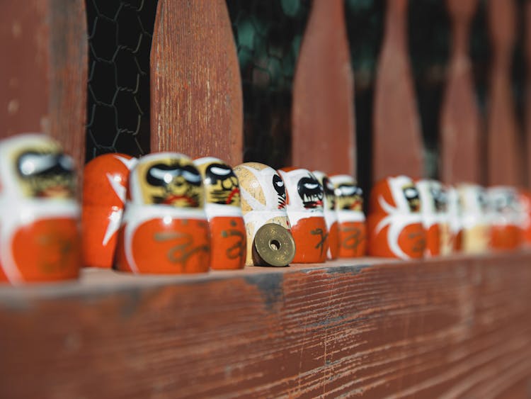 Daruma Dolls On Wooden Fence