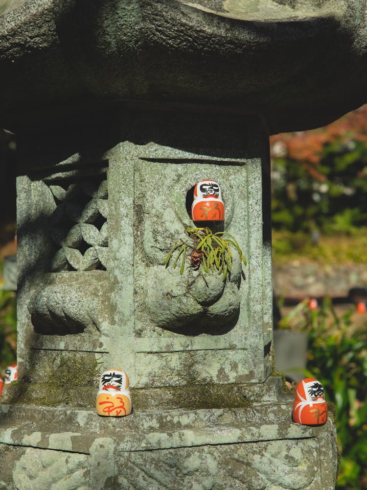 Red Daruma Dolls On Stone Column