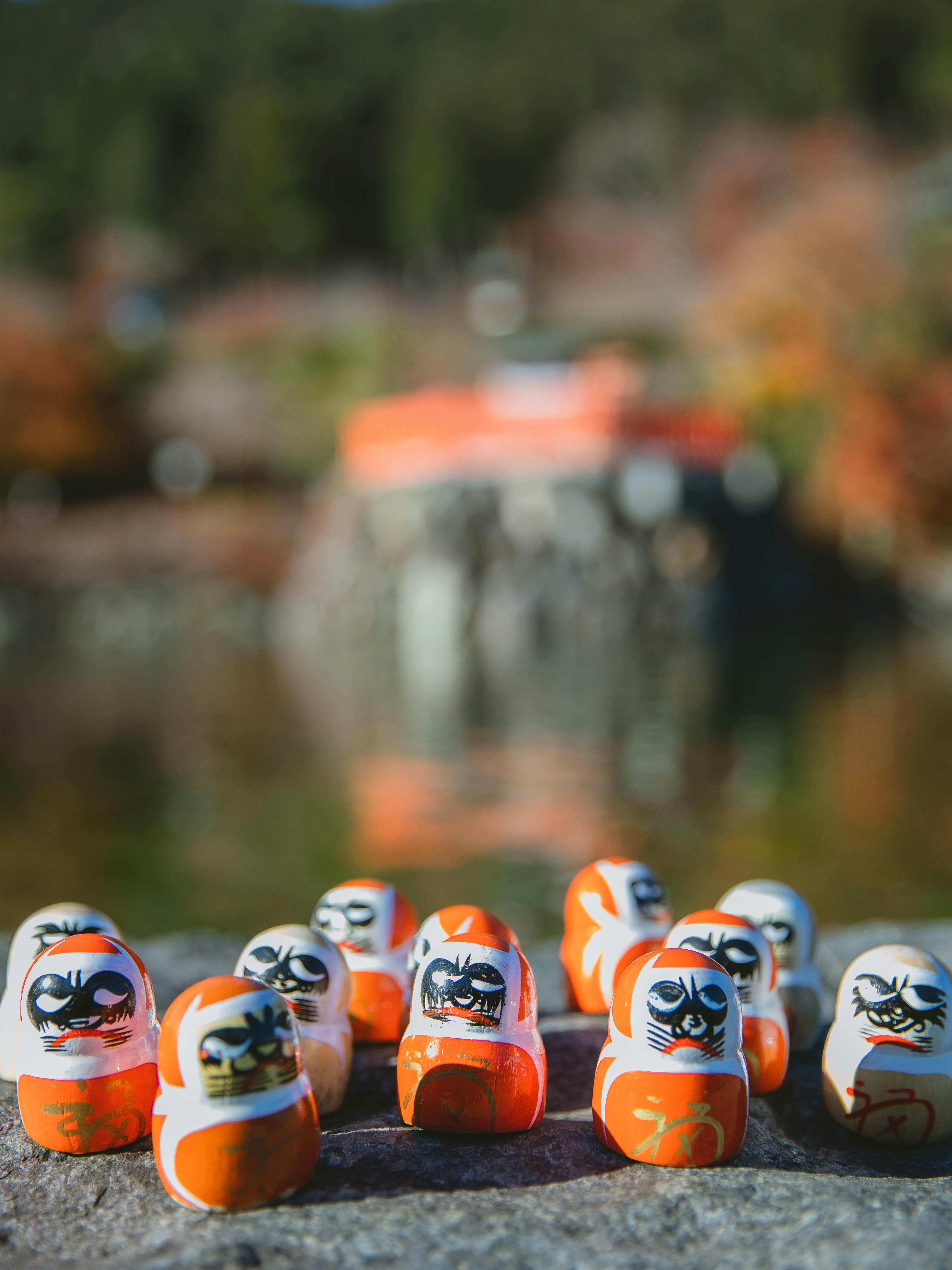 daruma dolls on asphalt surface in nature