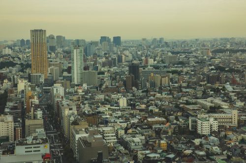 Free Drone view of tall dense contemporary houses of big city under smog and cloudy sky Stock Photo