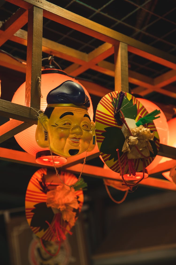 Traditional Chinese Lanterns And Mask Hanging On Metal Bar