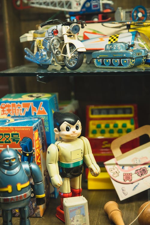 Collection of assorted toys including robots motorcycle and tank for sale in Japanese store