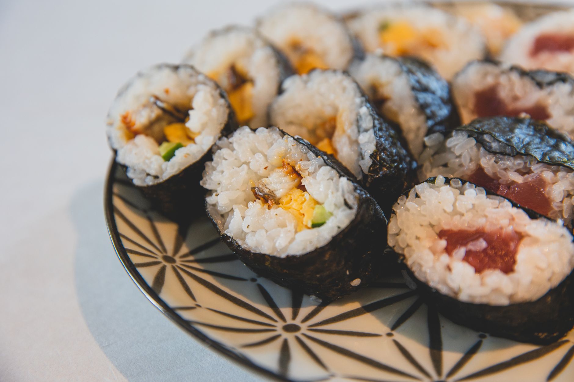 Futomaki sushi sliced and served with soy sauce and wasabi on a wooden platter