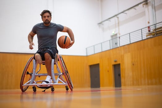 A male wheelchair basketball player practicing indoors on a court.
