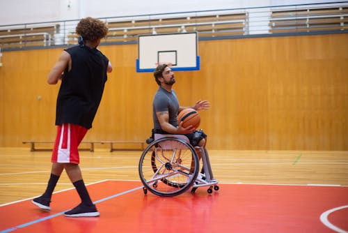 Man in Black Shirt and Red Shorts Playing Basketball