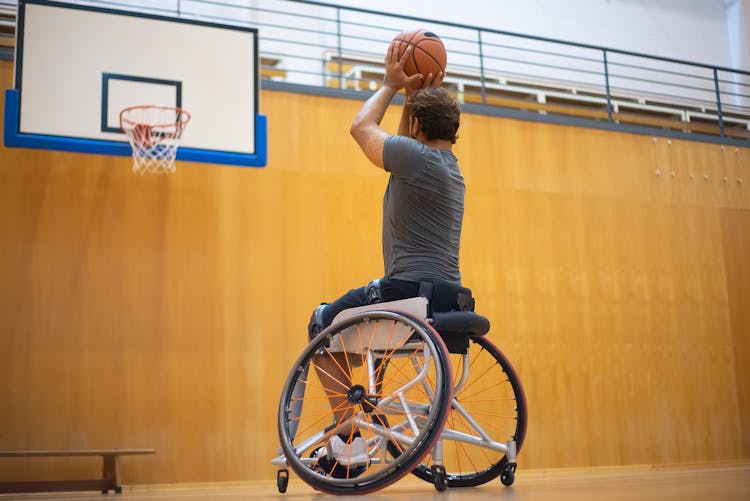 Man In A Gray Shirt Shooting A Basketball