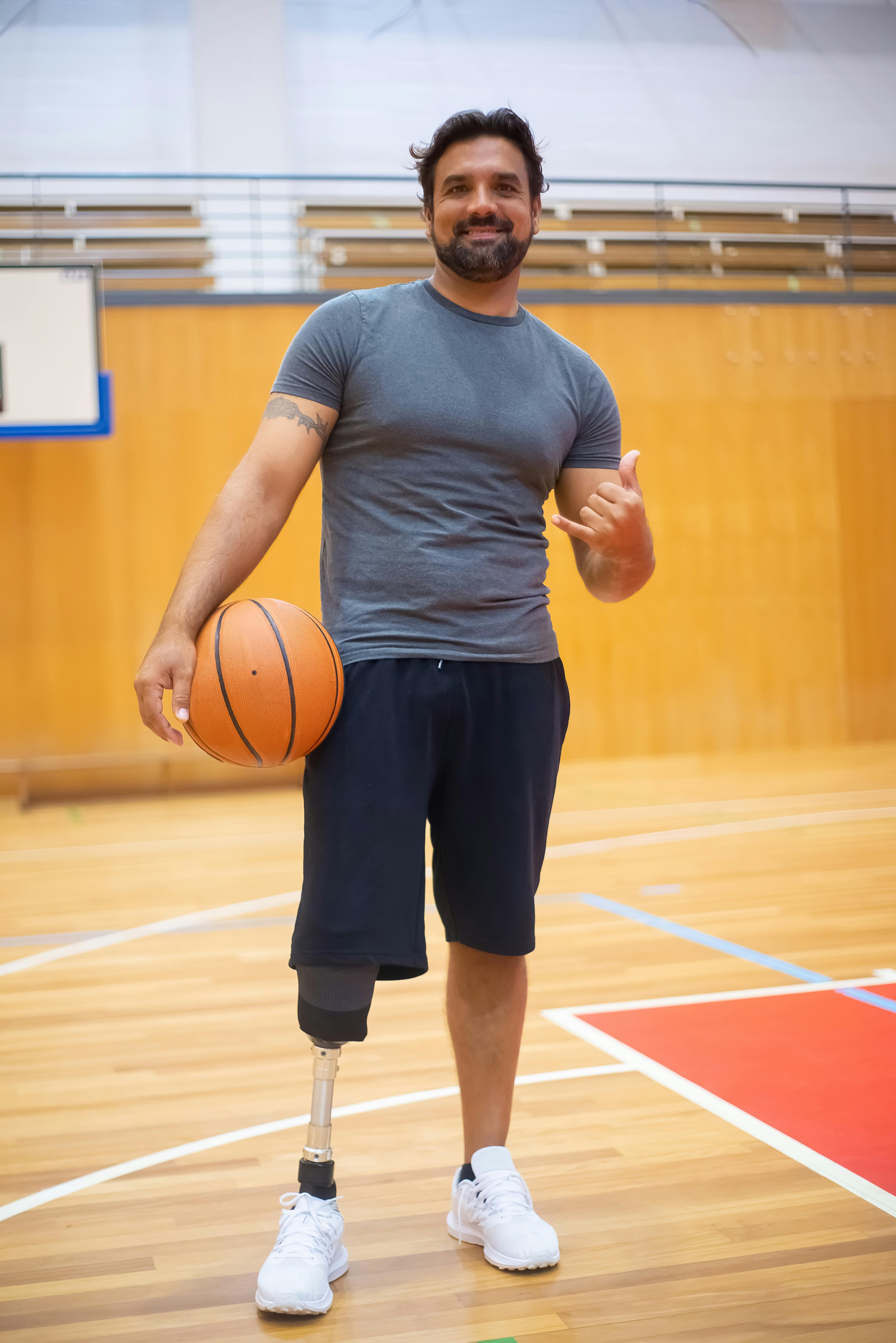 photo of a man in a gray shirt standing with an orange basketball