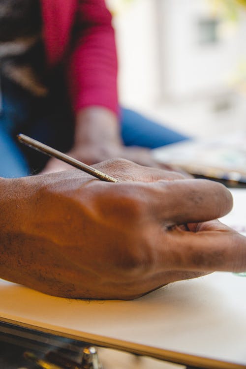 Crop black man drawing with paintbrush