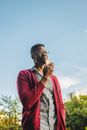 Cheerful black man with smartphone on street