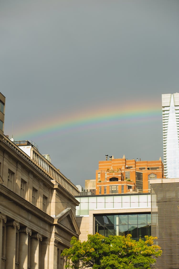 Modern And Old City Buildings Under Rainbow