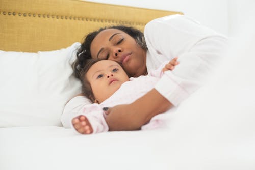 Free Photograph of a Mother Sleeping with Her Daughter on a Bed Stock Photo