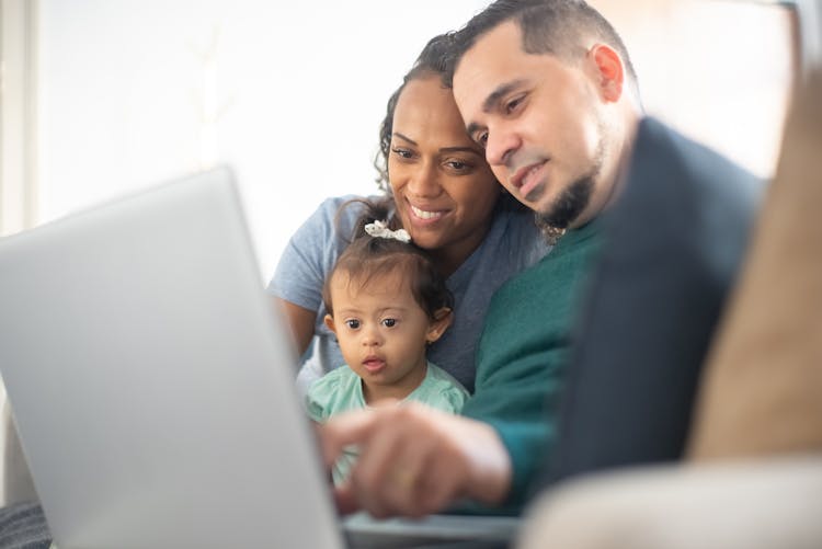 A Family Looking At A Laptop