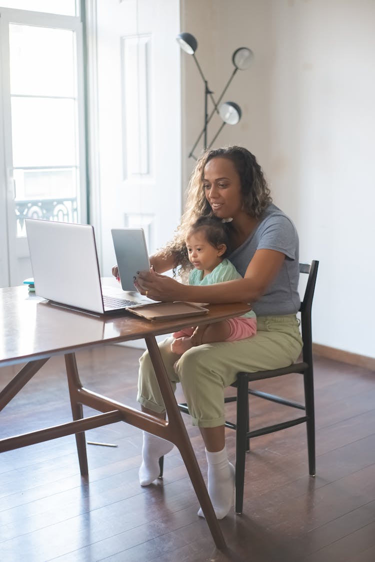 A Mother Taking Care Of Her Daughter While Working