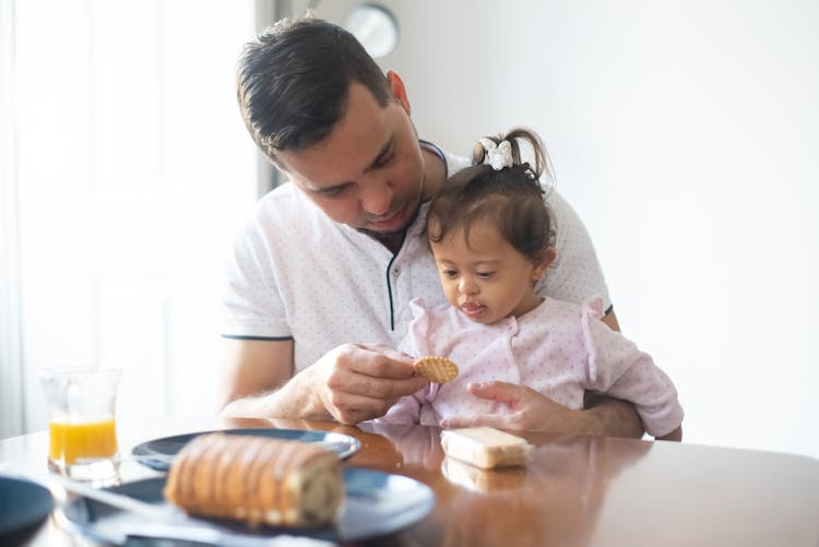 Father Giving Her Daughter A Cracker