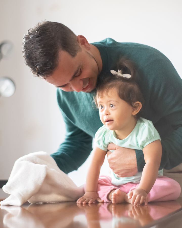 Father sharing a warm moment with his daughter with Down syndrome at home