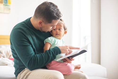 Free Photograph of a Father Reading a Book for Her Daughter Stock Photo